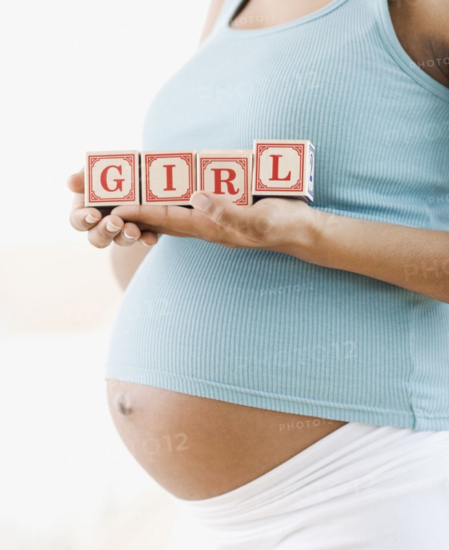 Pregnant African American woman holding 'GIRL' blocks