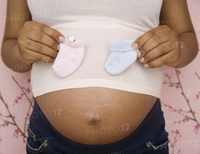 Pregnant African American woman holding booties