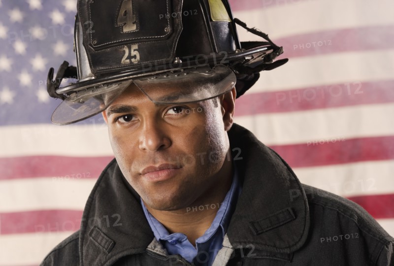 Hispanic male firefighter in front of American flag