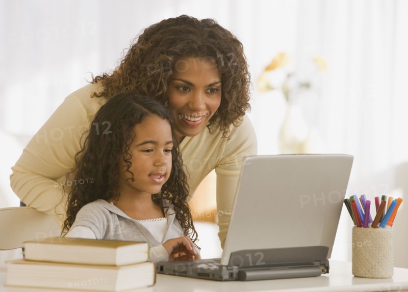 African mother and daughter looking at laptop