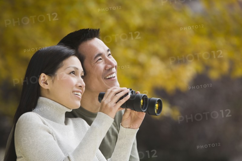 Asian couple holding binoculars