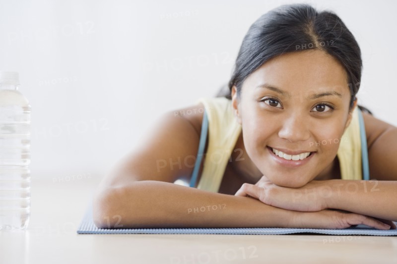 Pacific Islander woman laying on yoga mat
