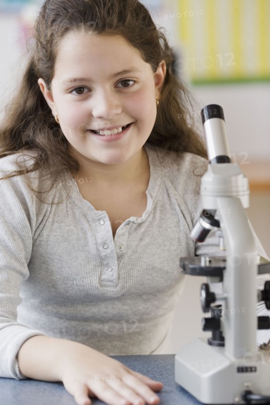 Hispanic girl next to microscope