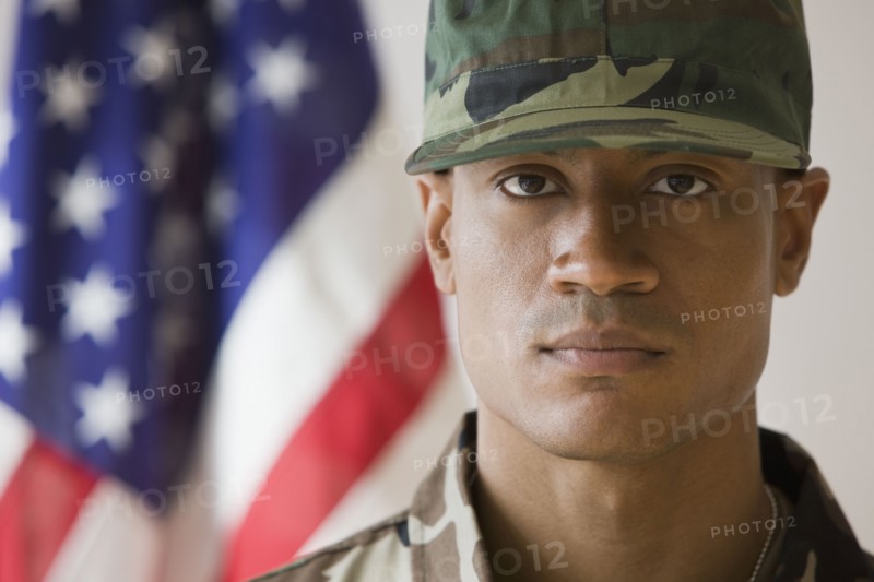 African male soldier in front of American flag