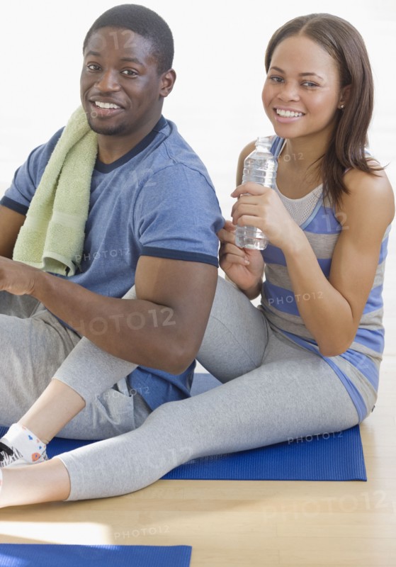 African couple sitting on yoga mat