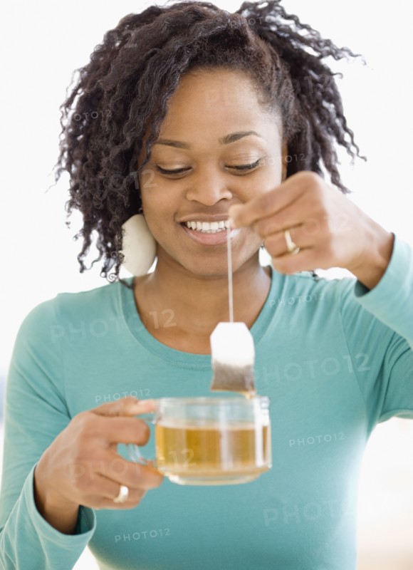 African woman holding tea bag