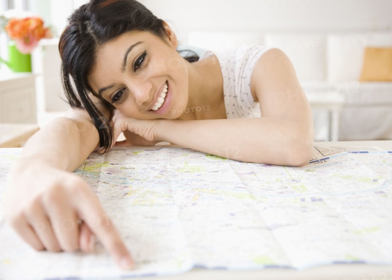 Mixed Race woman pointing to map
