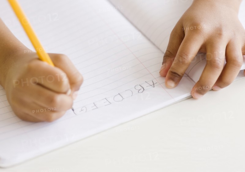 Mixed race girl writing ABC's