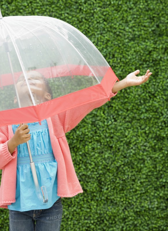 Mixed race girl with umbrella in the rain