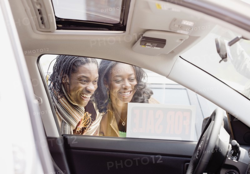 African couple looking at car for sale