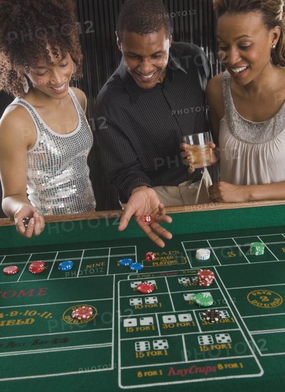 African man and women playing craps at casino