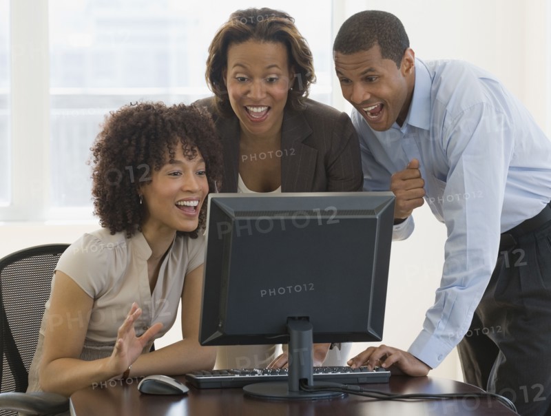 African people looking excited working on computer