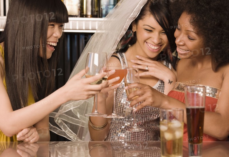 Multi-ethnic friends drinking in nightclub for bachelorette party