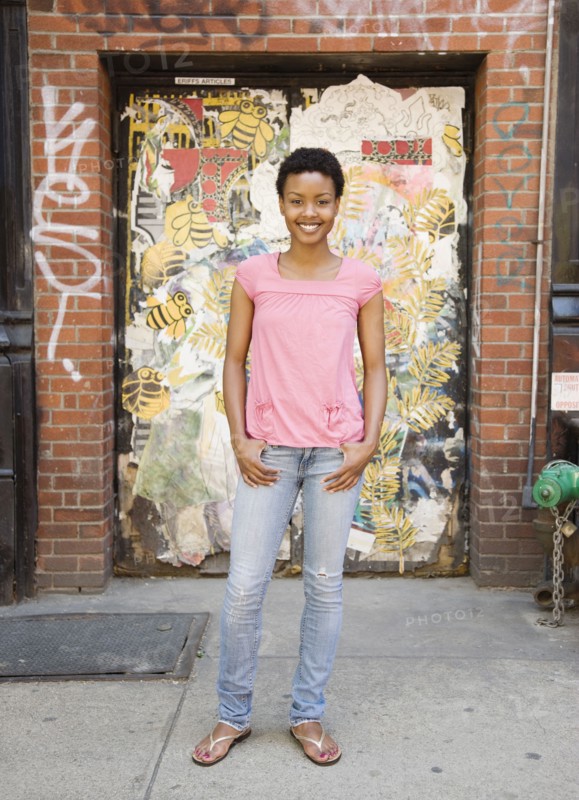 African woman standing near urban doorway