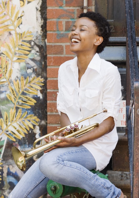 African woman holding trumpet outdoors