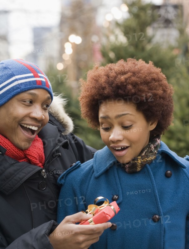 African man giving girlfriend Christmas present