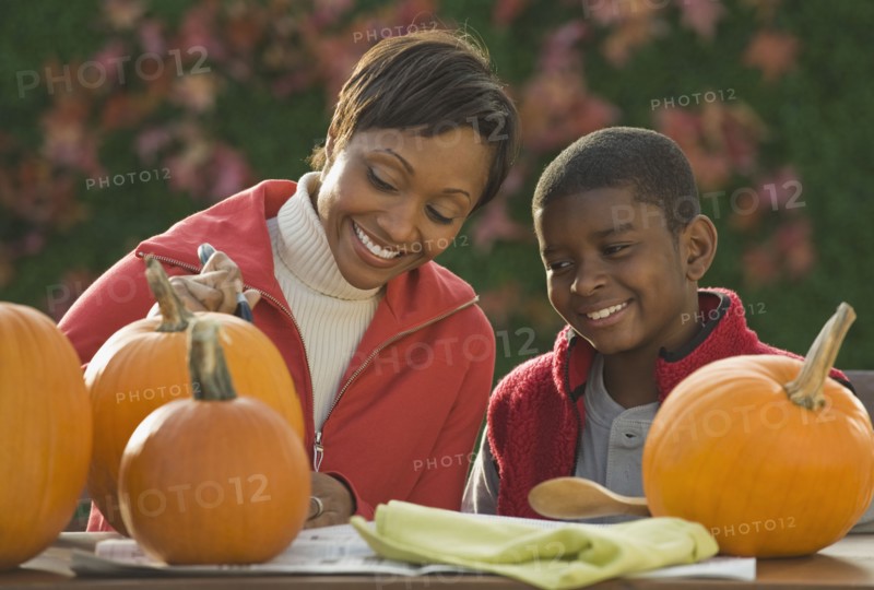 African mother and son carving pumpkins