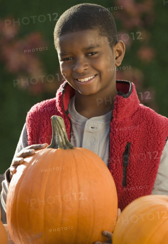 African boy holding pumpkin