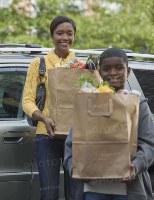 African boy helping mother unload groceries