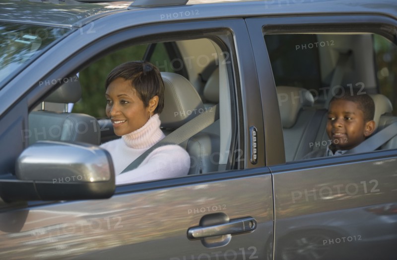 African mother and son driving in car