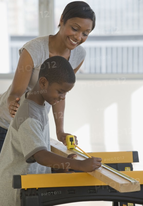 African mother and son woodworking together