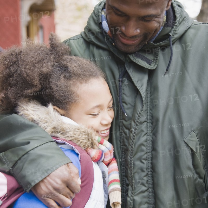 African father hugging daughter