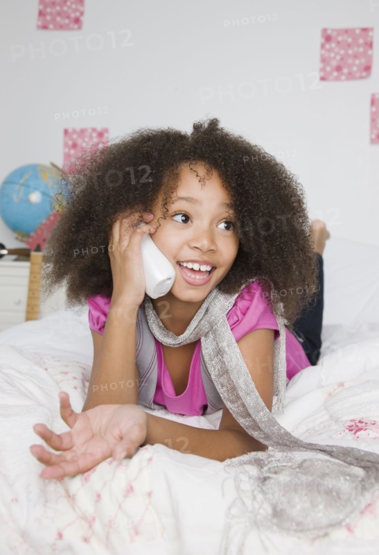 African girl using telephone on bed