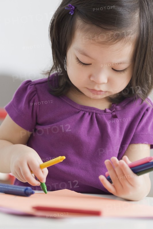 Toddler girl coloring with crayons