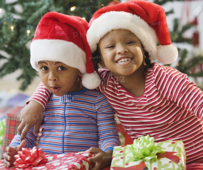 African American brother and sister holding Christmas gifts