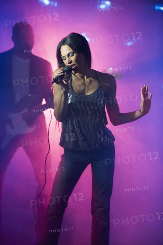 Mixed race woman singing at nightclub