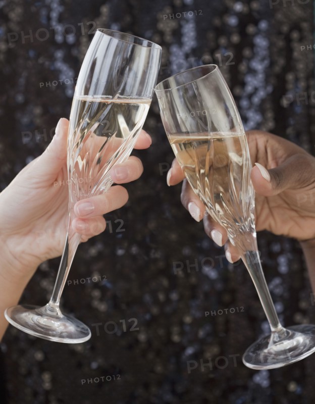 African and Caucasian woman toasting with champagne