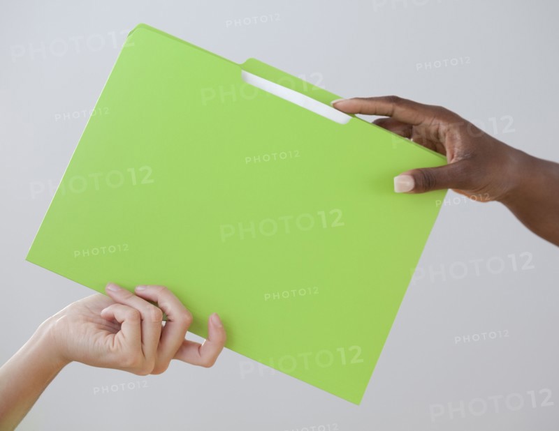 African woman handing co-worker a folder