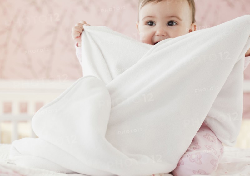 Mixed race baby girl playing with blanket