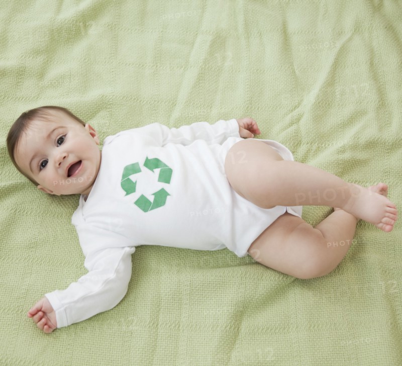 Mixed race baby girl with recycling symbol on shirt