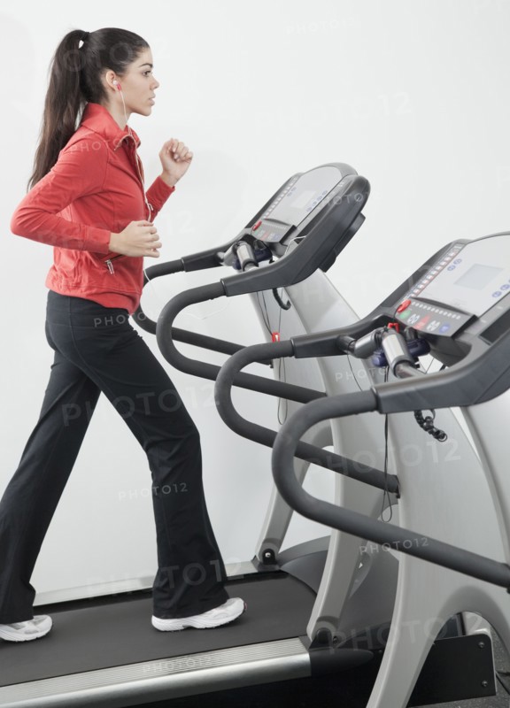 Hispanic woman walking on treadmill