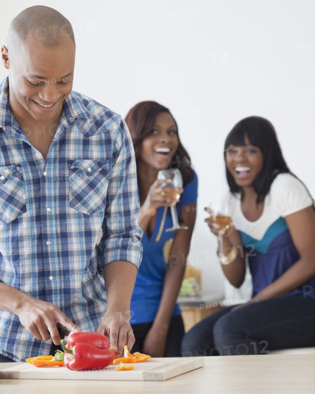 African man preparing dinner for friends