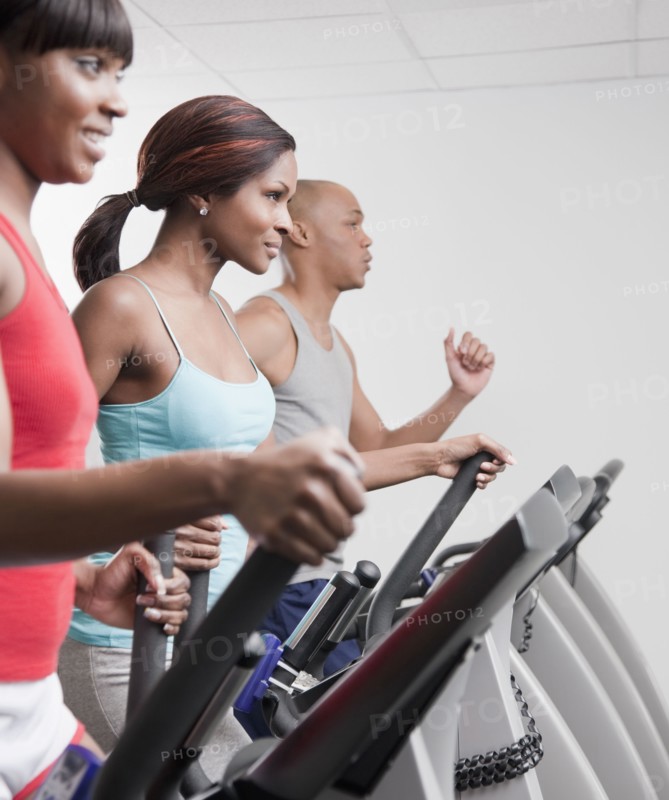 African people using exercise equipment in health club