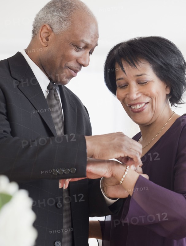 African man attaching bracelet for wife
