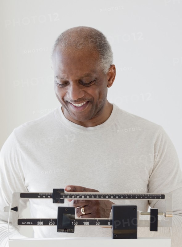 African man weighing himself