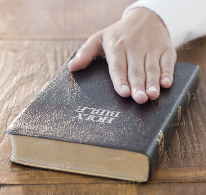Woman's hand on Bible