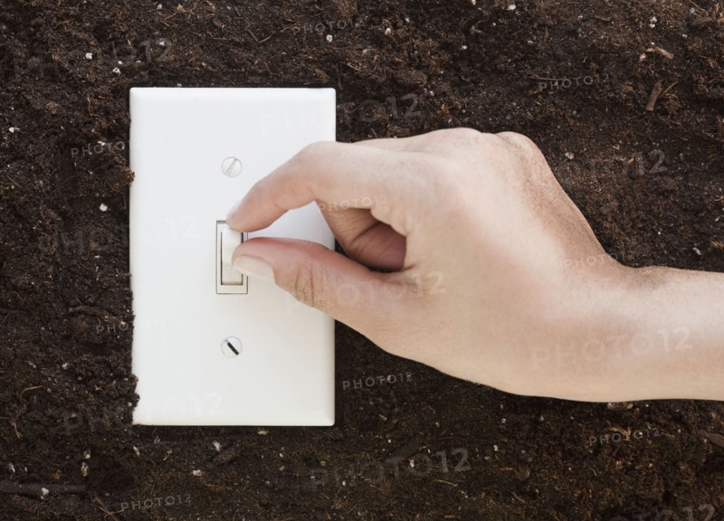 Woman flipping light switch in soil