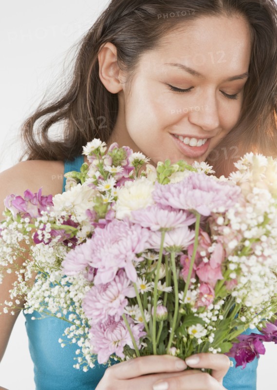Mixed race woman holding bouquet of flowers