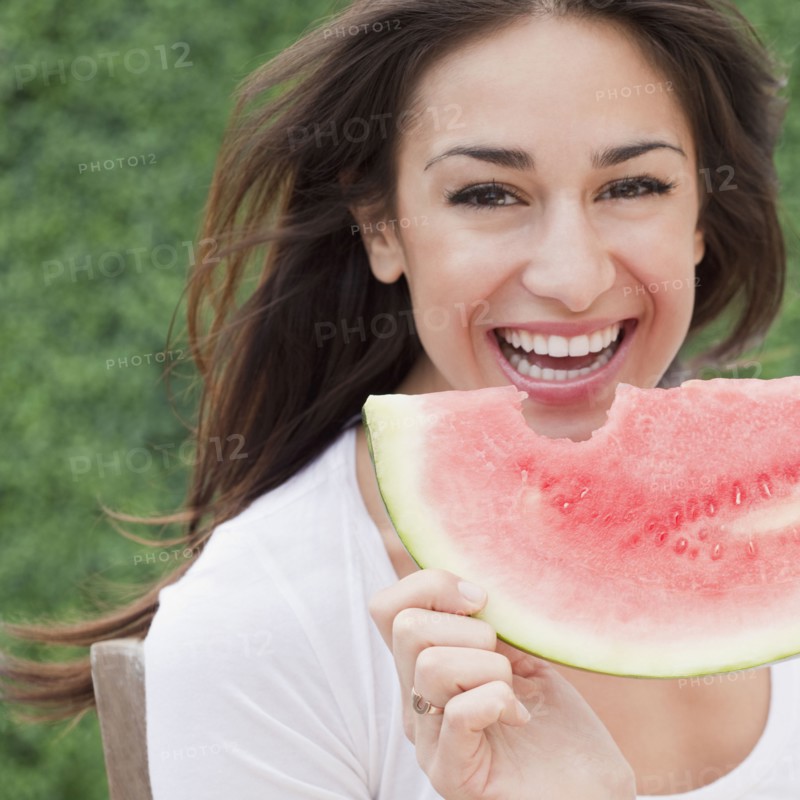 Hispanic woman eating watermelon