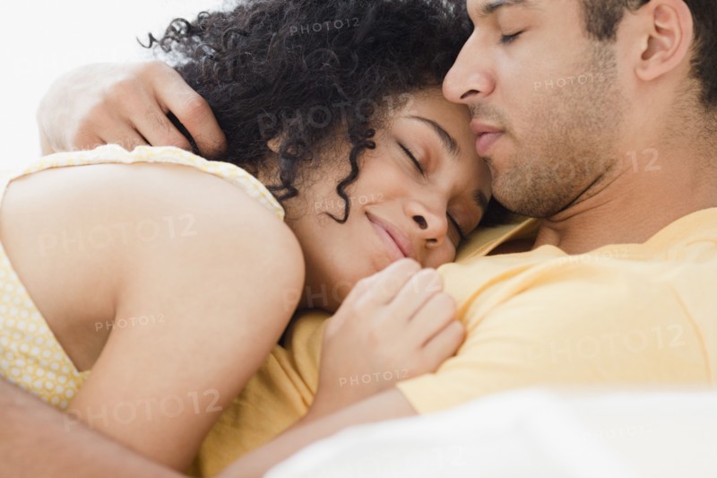 Couple cuddling on bed
