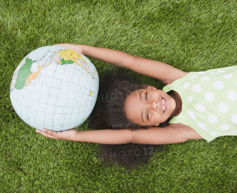 Mixed race girl holding globe