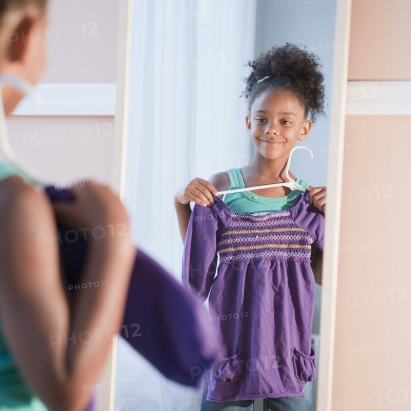 Mixed race girl looking at shirt