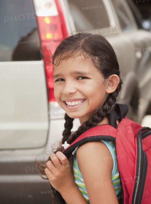 Smiling Hispanic girl carrying backpack