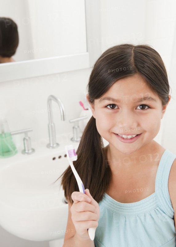 Mixed race girl holding toothbrush