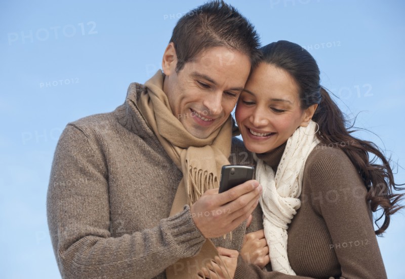 Hispanic couple looking at cell phone