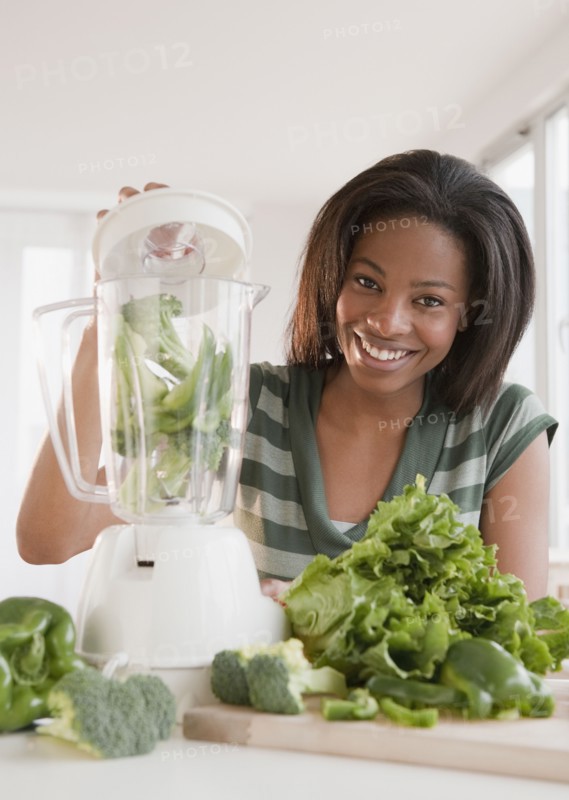 Mixed race woman blending vegetables